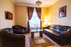 a living room with two leather couches and a window at Hotel Europa in Târgu Jiu