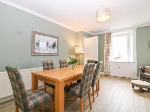 a dining room with a wooden table and chairs at White Hillocks Farm House in Inchmill