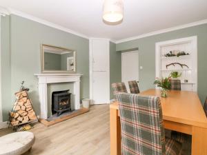 a living room with a table and a fireplace at White Hillocks Farm House in Inchmill