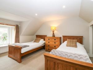 a bedroom with two beds and a window at White Hillocks Farm House in Inchmill