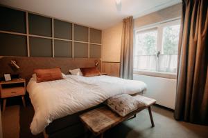 a bedroom with a large bed and a window at Witte Berken Natuurhotel in Epe +69 photos