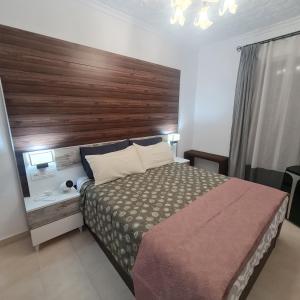 um quarto com uma cama grande e uma cabeceira em madeira em AM house em Burriana