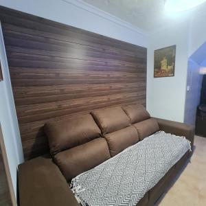 Sofá marrón en una habitación con pared de madera en AM house en Burriana