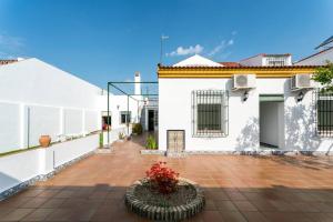 un patio de una casa blanca con una maceta de flores en La Francesa Doñana, en Villamanrique de la Condesa