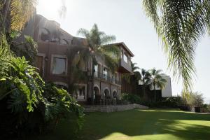 duży dom z trawnikiem przed nim w obiekcie Hotel Grand María w mieście Morelia