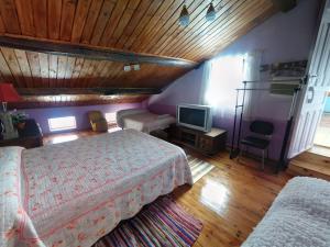 1 dormitorio con 1 cama y TV. en Casa de los Balcones La Bañeza León 