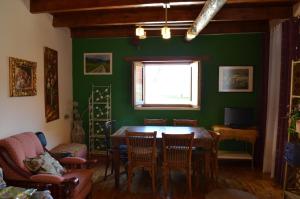 ein Esszimmer mit einem Tisch und einer grünen Wand in der Unterkunft Casa de los Balcones La Bañeza León 