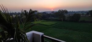 einen Sonnenuntergang vom Balkon eines Hauses in der Unterkunft unTrained & unPlanned in Jabalpur