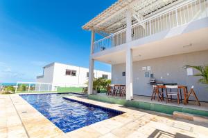 a house with a swimming pool in front of a house at Beach Townhouses #C6 - Triplex por Carpediem in Mangabeira +36 photos