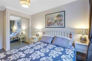 Schlafzimmer mit einem blauen und weißen Bett und einem Spiegel in der Unterkunft Riverside in Kent