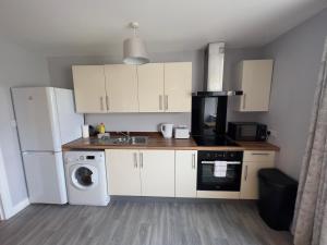 a kitchen with white cabinets and a sink and a dishwasher at Princes Court, Sea Road in Bournemouth