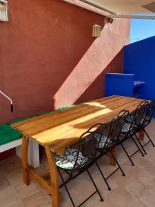 une table en bois avec deux chaises et un escalier dans l'établissement Ksar azul 6 pers à 2 mn de la plage, à La Vila Joiosa