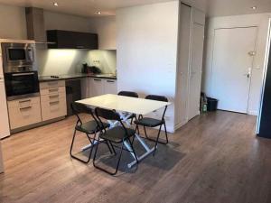 uma cozinha com mesa e cadeiras num quarto em Appartement moderne 2 pièces em Cagnes-sur-Mer