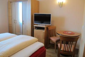 Habitación de hotel con cama y mesa pequeña con TV en Landgasthof Schwabenpfanne, en Erbach