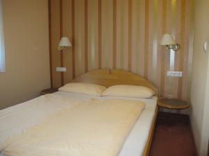 2 camas en una habitación pequeña con 2 lámparas en Landgasthof Schwabenpfanne, en Erbach