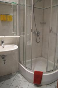 y baño con ducha y lavamanos. en Landgasthof Schwabenpfanne, en Erbach