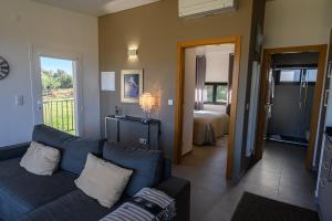 uma sala de estar com um sofá e um quarto em Laje da Bica Agroturismo na Covilhã