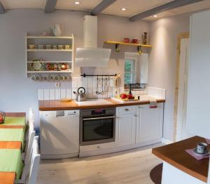 a kitchen with white appliances and a wooden floor at Dom Sielski w Górach Stołowych in Radków