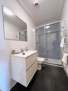 Baño blanco con lavabo y aseo en Estudio céntrico 2 con terraza y parking privado, en Ourense