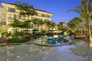 a hotel with a swimming pool in front of a building at Bali Nusa Dua Hotel in Nusa Dua