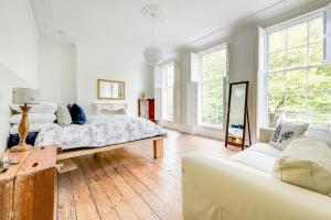 een witte slaapkamer met een bed en een bank bij Host & Stay - The Georgian Townhouse in Liverpool