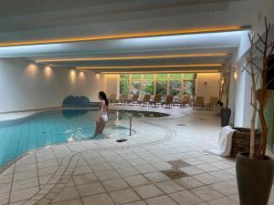 a woman standing next to a swimming pool at Weingut Bachgütl in Cermes