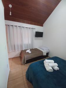a small room with two beds and a window at Suites Estrela in São Pedro da Serra