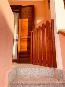 a wooden entrance to a house with a wooden gate at Casa Jane in Villasimius