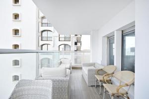 a balcony with white furniture and windows at Orchid Hotel by HolyGuest in Tel Aviv