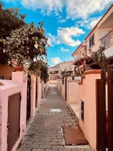 an alley in a town with pink buildings at Casa Jane in Villasimius