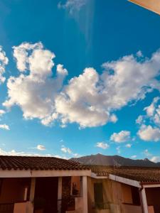 un cielo azzurro con nuvole bianche sopra un edificio di Casa Jane a Villasimius
