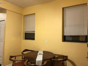 Zimmer mit einem Tisch und Stühlen sowie 2 Fenstern in der Unterkunft Room 2 in Chicago