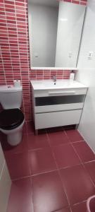 ein Badezimmer mit einem weißen Waschbecken und einem WC in der Unterkunft Happy Nogalera Centro - Vistas al Mar in Torremolinos