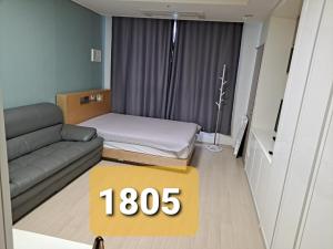 GimcheonにあるGimcheon Gumi KTX Yulgokdong Apartmentのベッド1台とソファが備わる小さな客室です。