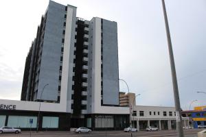 a tall building with cars parked in a parking lot at Home away from Home in Windhoek