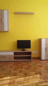 een kamer met een flatscreen-tv aan een gele muur bij Coqueto alojamiento cercano a las termas in Ourense