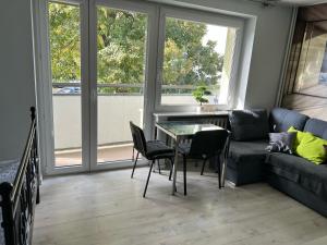 Una sala de estar con un sofá, una mesa y sillas. en Apartament Baltic Sea, en Gdansk