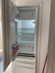 - un réfrigérateur vide avec une porte ouverte dans la cuisine dans l'établissement Kaza Loulou, à Saint-François