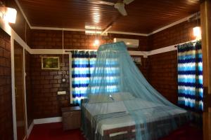 een slaapkamer met een bed met een blauwe klamboe bij Doctors Ayurveda Heritage in Varkala