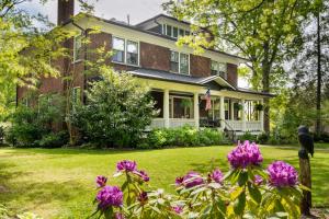 a brick house with purple flowers in the yard at Sweet Biscuit Inn in Asheville