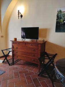 una TV in cima a un comò in legno in una stanza di Rustico La Rosa a Tivoli