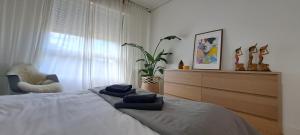 - une chambre avec un lit, une chaise et une fenêtre dans l'établissement Apartamento con suite, zona de trabajo y yoga wifi y garaje, à Castro Urdiales