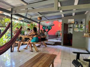 eine Gruppe von Menschen, die an einem Tisch in einem Restaurant sitzen in der Unterkunft Pura Vida Hostel in Montezuma