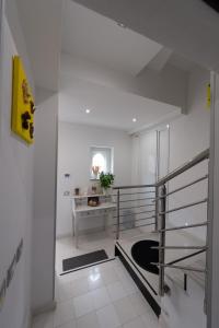 a white room with a desk and a staircase at Vacanze a Casa Pozzallo in Pozzallo