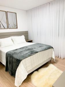 Un dormitorio con una cama grande y una ventana en Apto Vivere - Stay House Temporada, en Canela