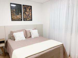 1 dormitorio blanco con 1 cama con 2 almohadas en Apto Vivere - Stay House Temporada, en Canela