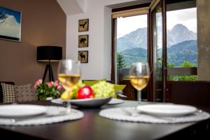 考斯賽力克的住宿－Mountain Apartments Butorowy Residence，一张桌子,上面放着两杯葡萄酒和一碗水果