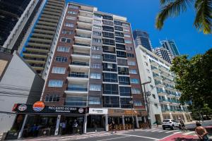 un edificio alto en una calle de la ciudad con un edificio en Apartamento Frente Mar, en Balneário Camboriú