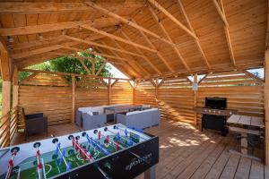 a large wooden patio with a table and a grill at Nowe Apartamenty Puck in Puck