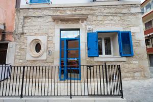 ポッツァッロにあるVacanze a Casa Pozzalloの青い扉と柵のある建物